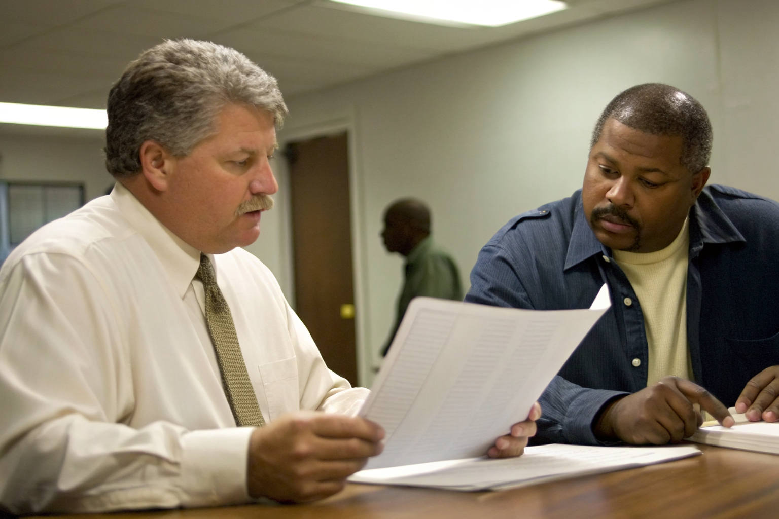Officials comparing FOG program documents in a meeting.