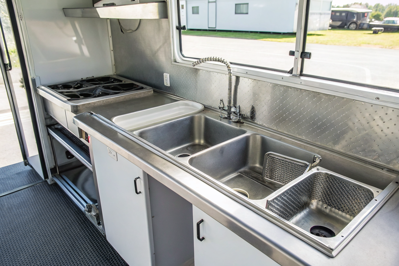 Food truck interior with compact grease trap under sink.