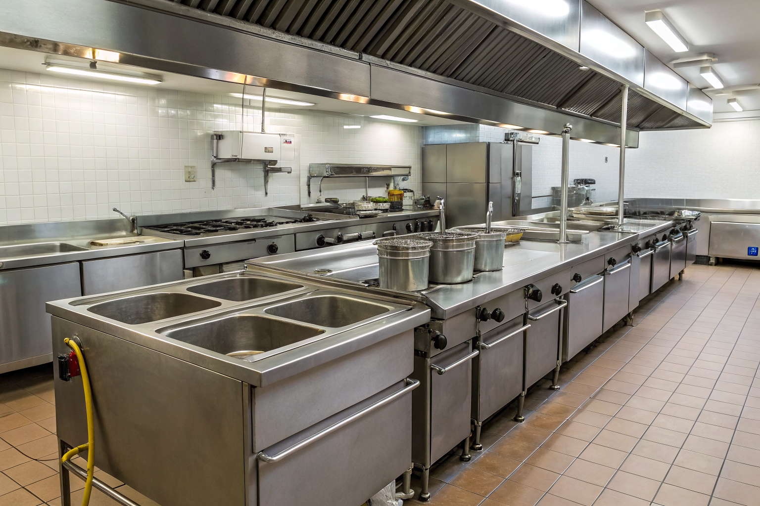 Restaurant kitchen with multiple grease traps and appliances.
