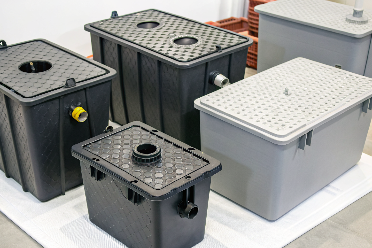 Different grease traps with labels showing GPM, price, and features.